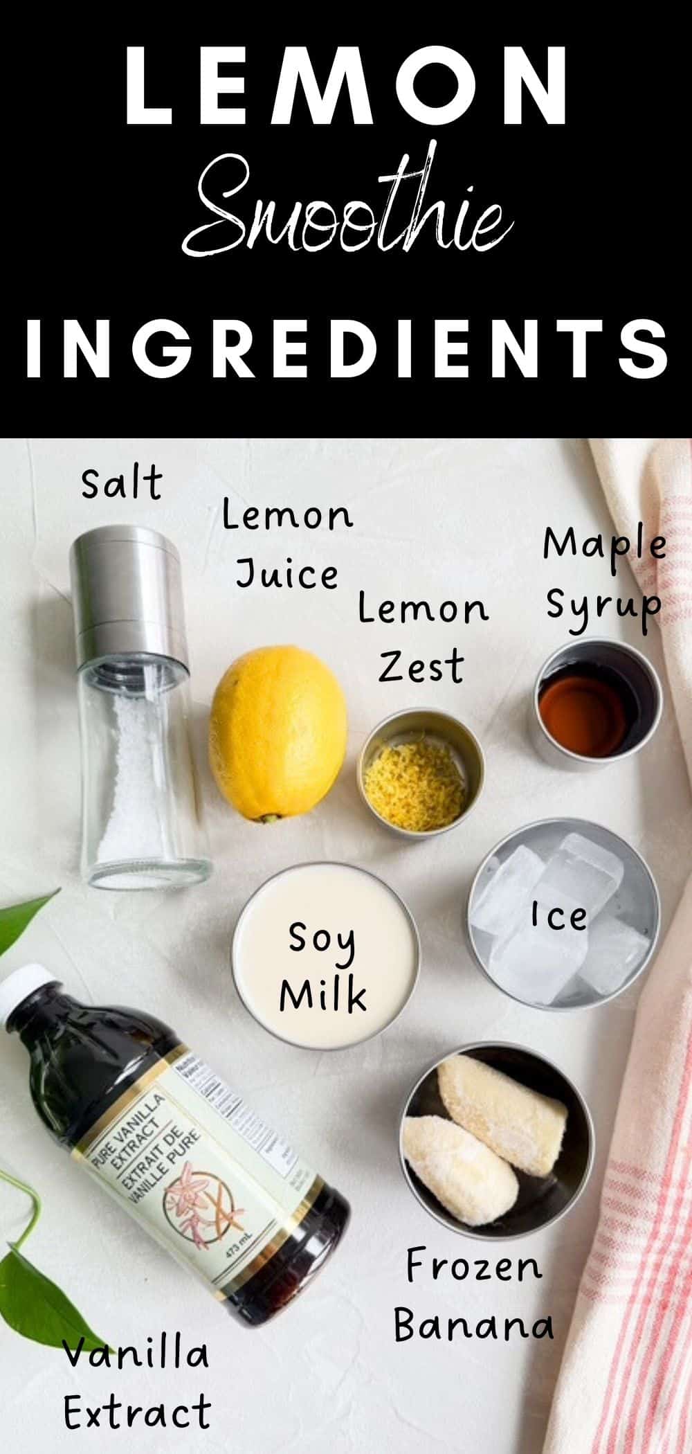 Flat lay of lemon smoothie ingredients including unsweetened soy milk, frozen banana, fresh lemon juice, lemon zest, maple syrup, vanilla extract, ice, and salt arranged in small bowls on a light background with a pink tea towel beside them