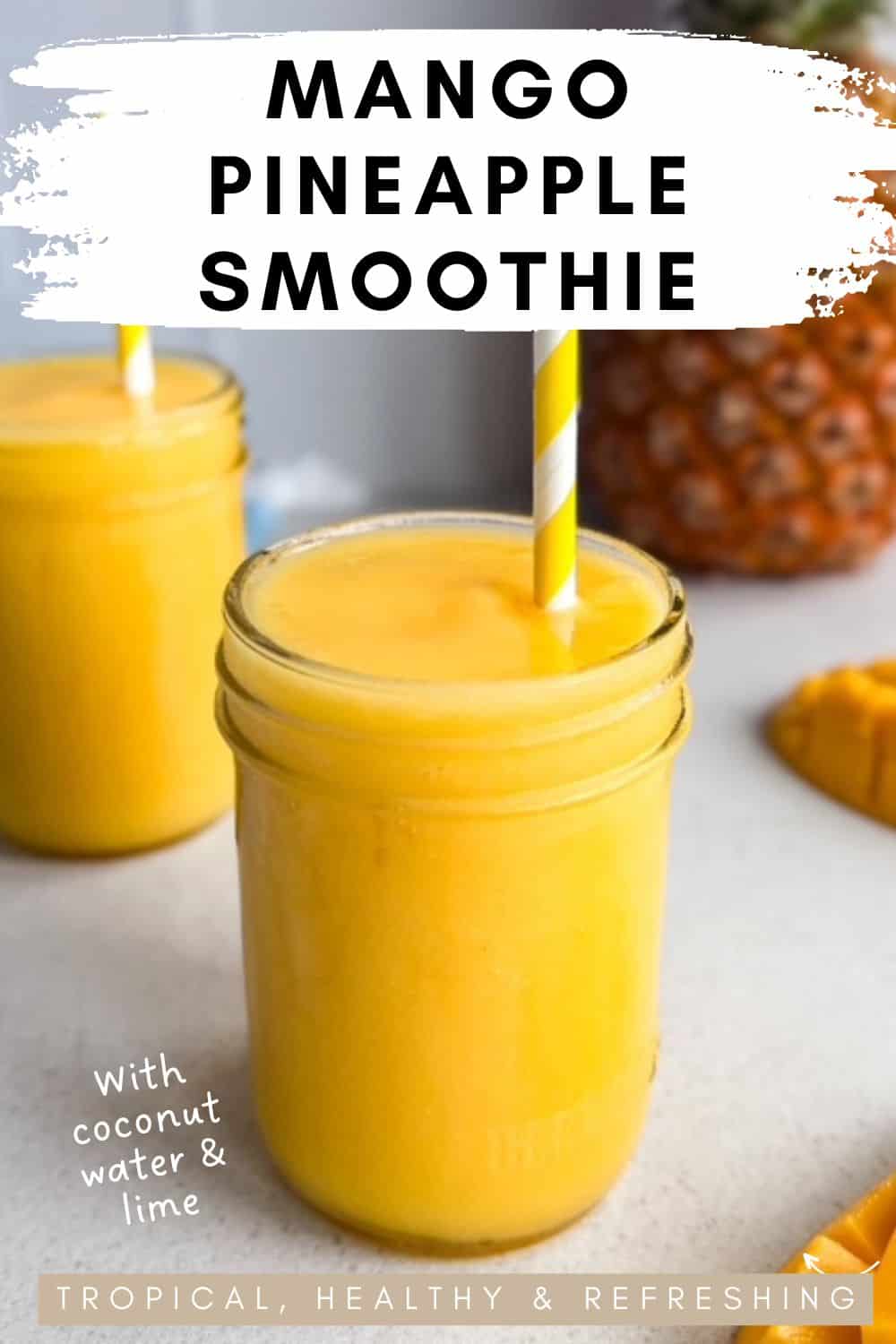 Mango pineapple smoothie in a glass jar with a striped straw, fresh mango and pineapple in the background and text overlay describing coconut water and lime