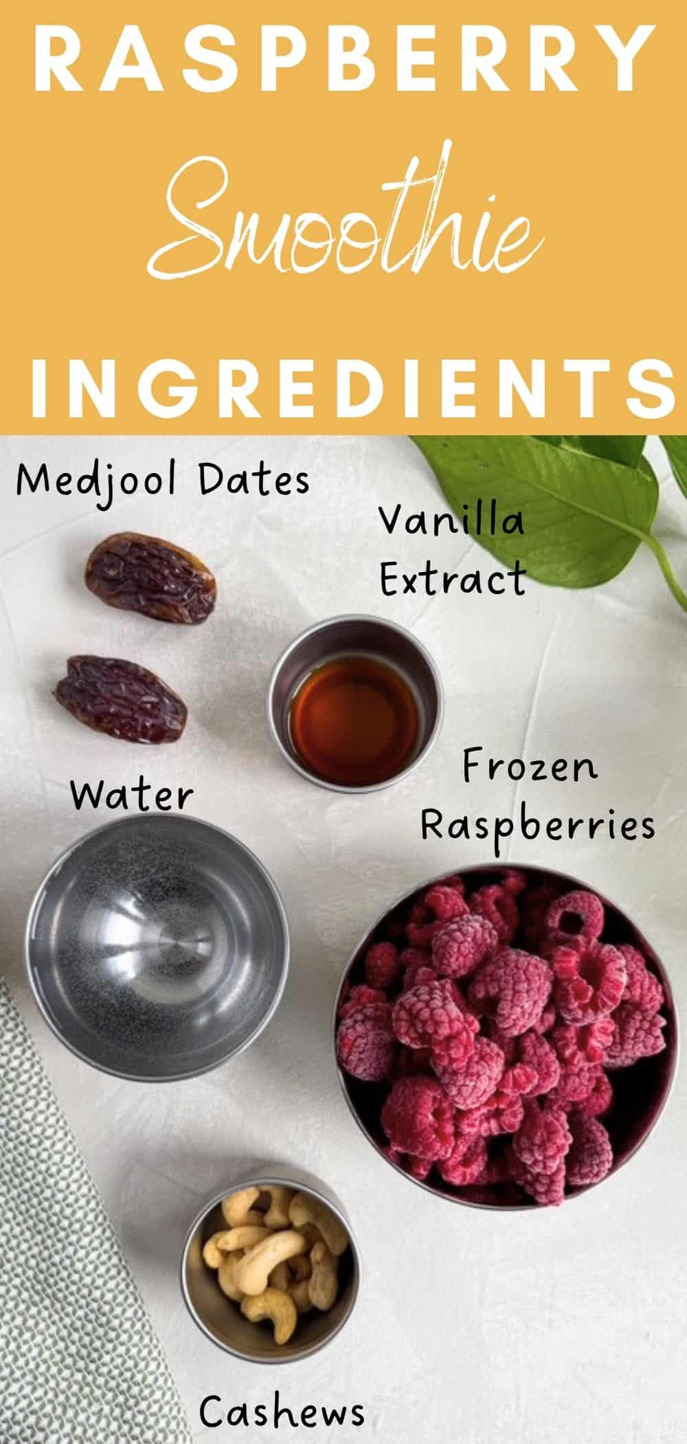 Raspberry smoothie ingredients including frozen raspberries, Medjool dates, cashews, vanilla extract, and water arranged on a white surface.