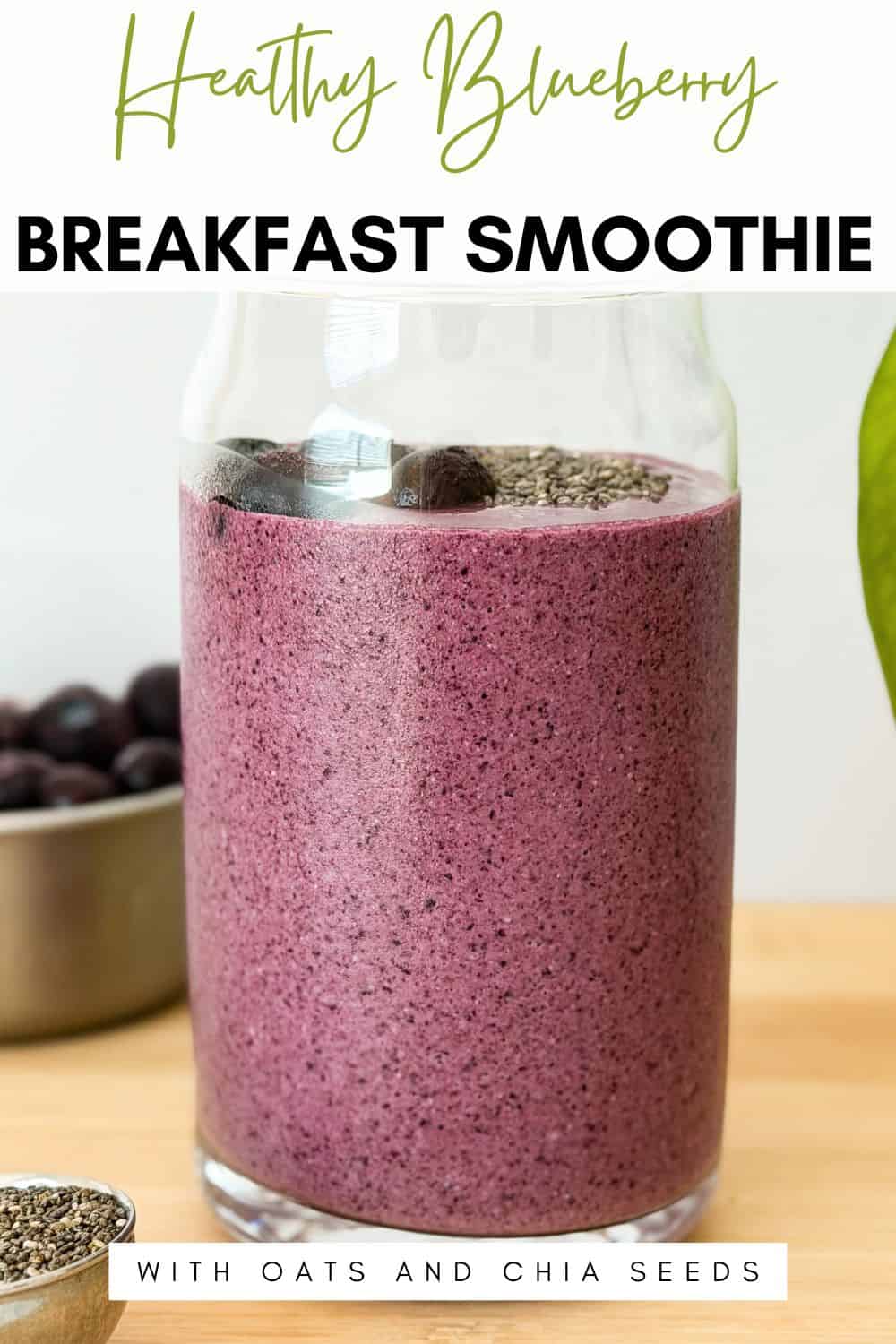 
Creamy purple blueberry breakfast smoothie in a glass, topped with whole blueberries and chia seeds, with fresh blueberries in the background.
Text overlay says healthy blueberry breakfast smoothie with oats and chia seeds.
